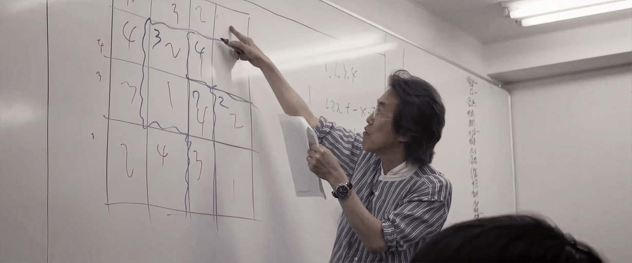Tetsuya Miyamoto working through a KenKen grid on a whiteboard