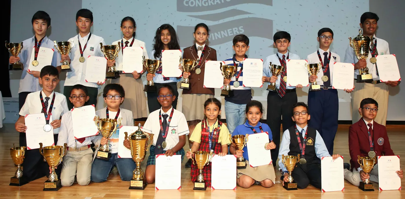 Young KenKen champions with their trophies and certificates on stage